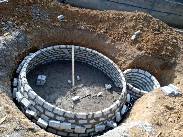 Brick-lined biodigester pit under construction